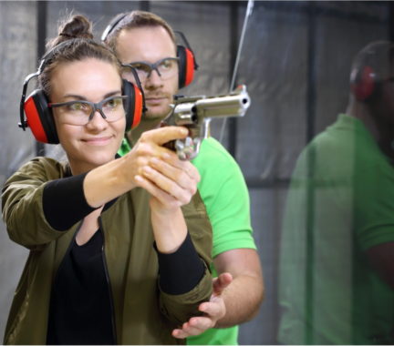 Shooting instructor helping a pistol shooter