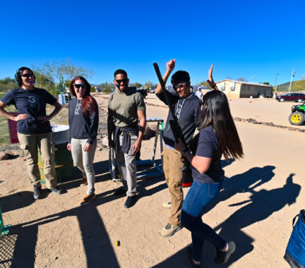 Group of people celebrating and laughing at a gun range